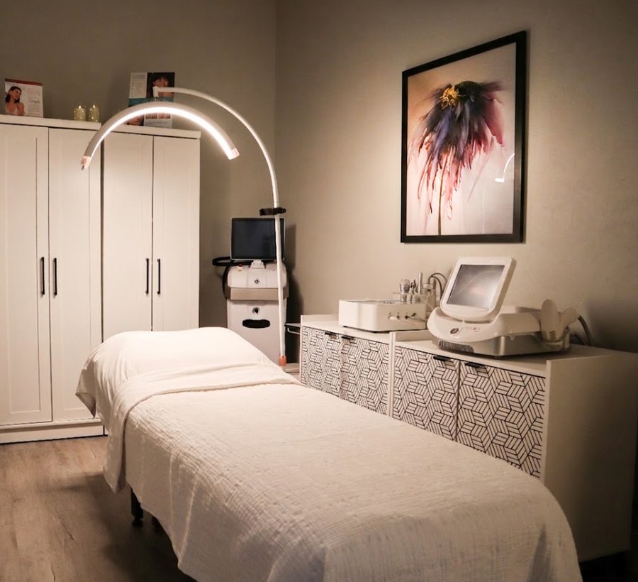 Treatment room with bed, skincare cabinet, and equipment
